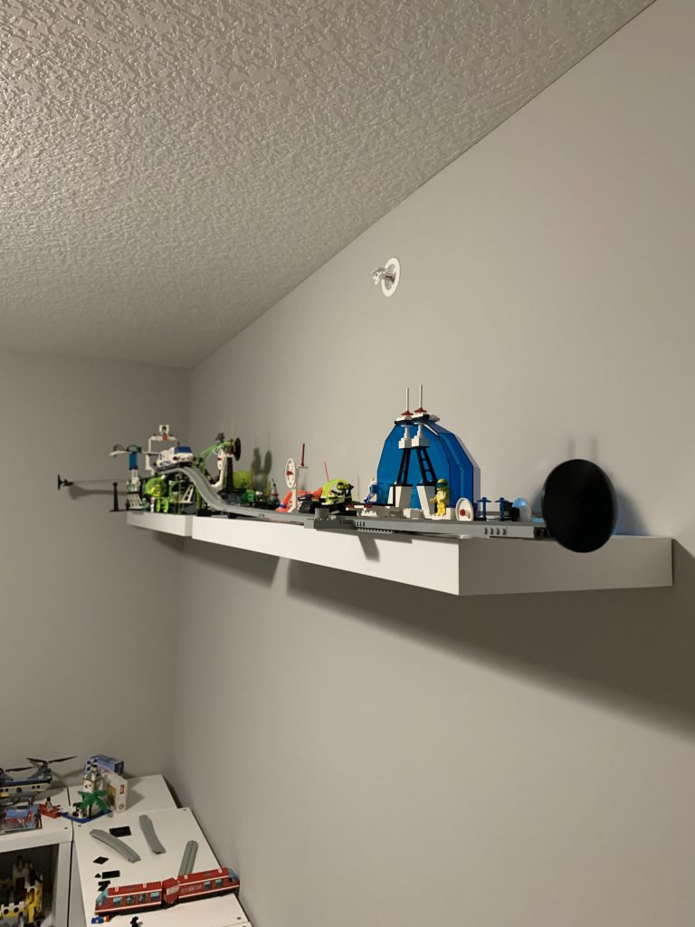 Photograph of shelving along side of wall holding monorail track and tram.