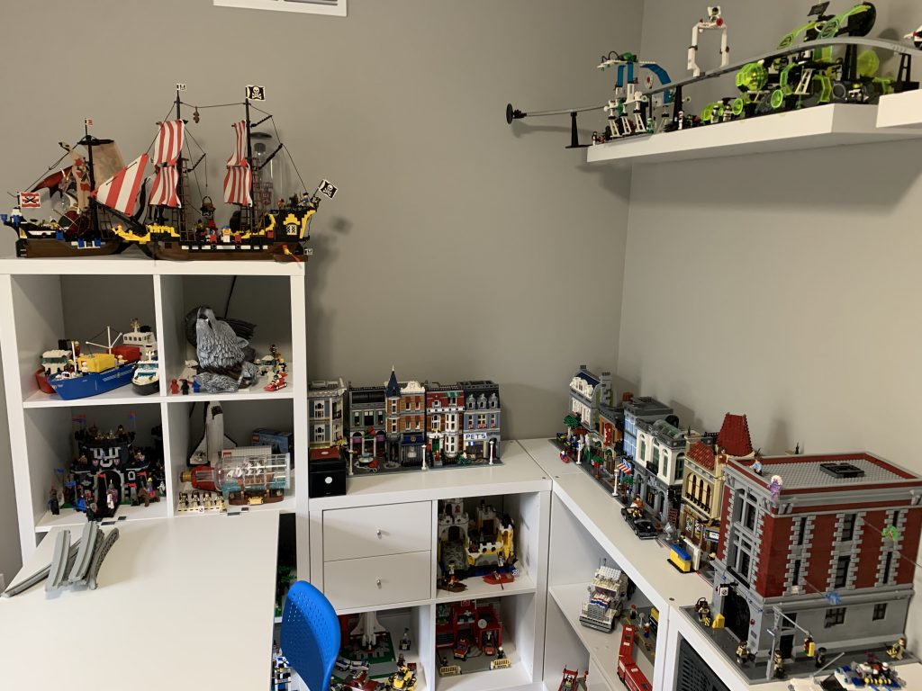 Photograph of game room mostly put together. LEGO sets sitting on top of and inside of cabinets.