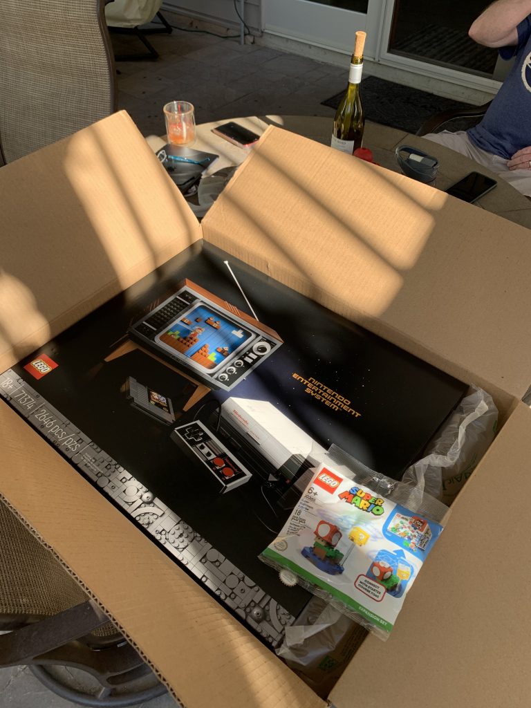 Photograph of receiving LEGO set 71374: Nintendo Entertainment System as a gift from parents. New box sitting inside shipping box from LEGO.
