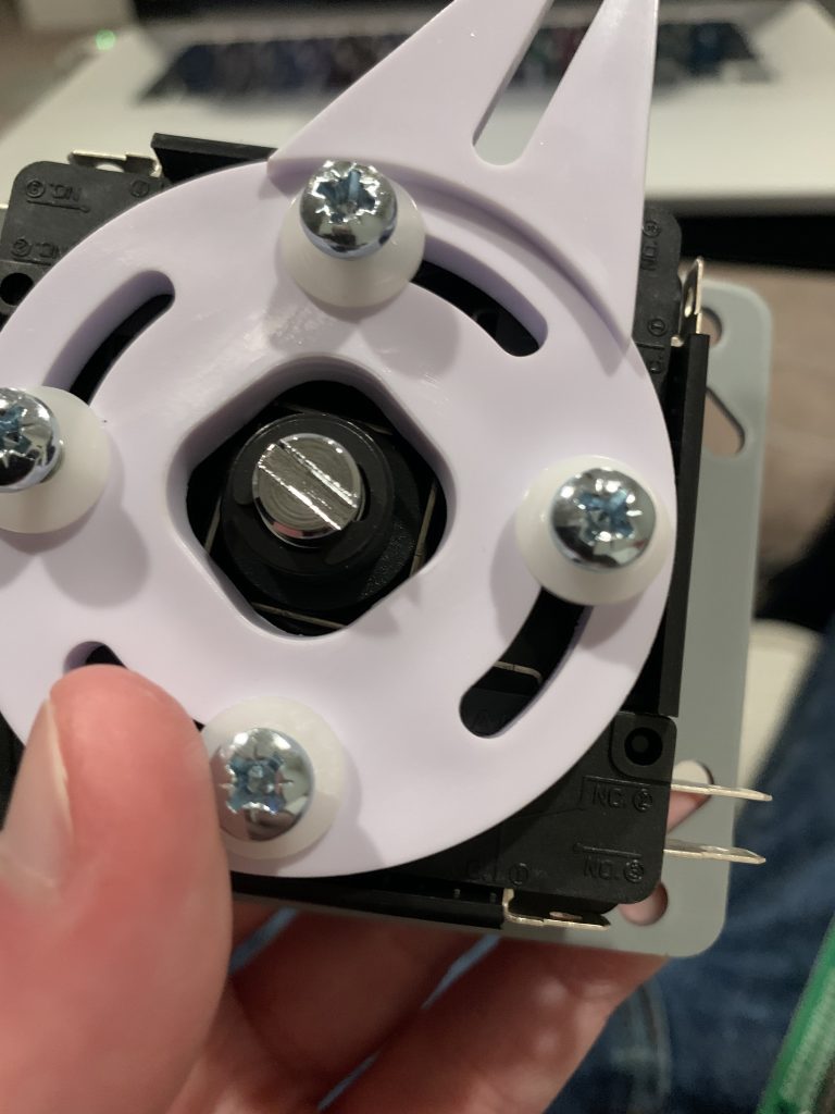 Photo showing a closeup of the mechanism that locks the joystick in 4-directional or 8-directional movement at the bottom of the joystick