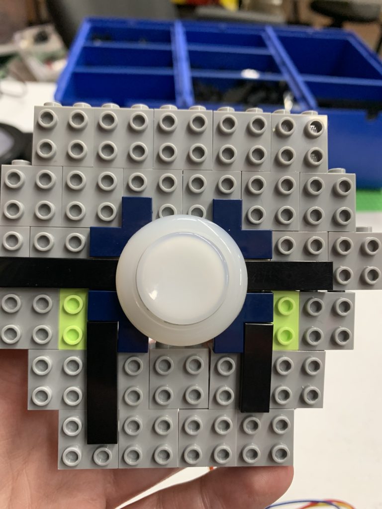 Photo showing button cradled between LEGO bricks.