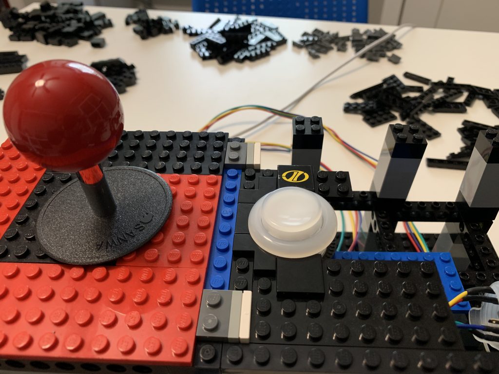 Photo showing player 1 joystick and a button half attached beside it. Finding out just how much of a challenge of mounting buttons this will be.