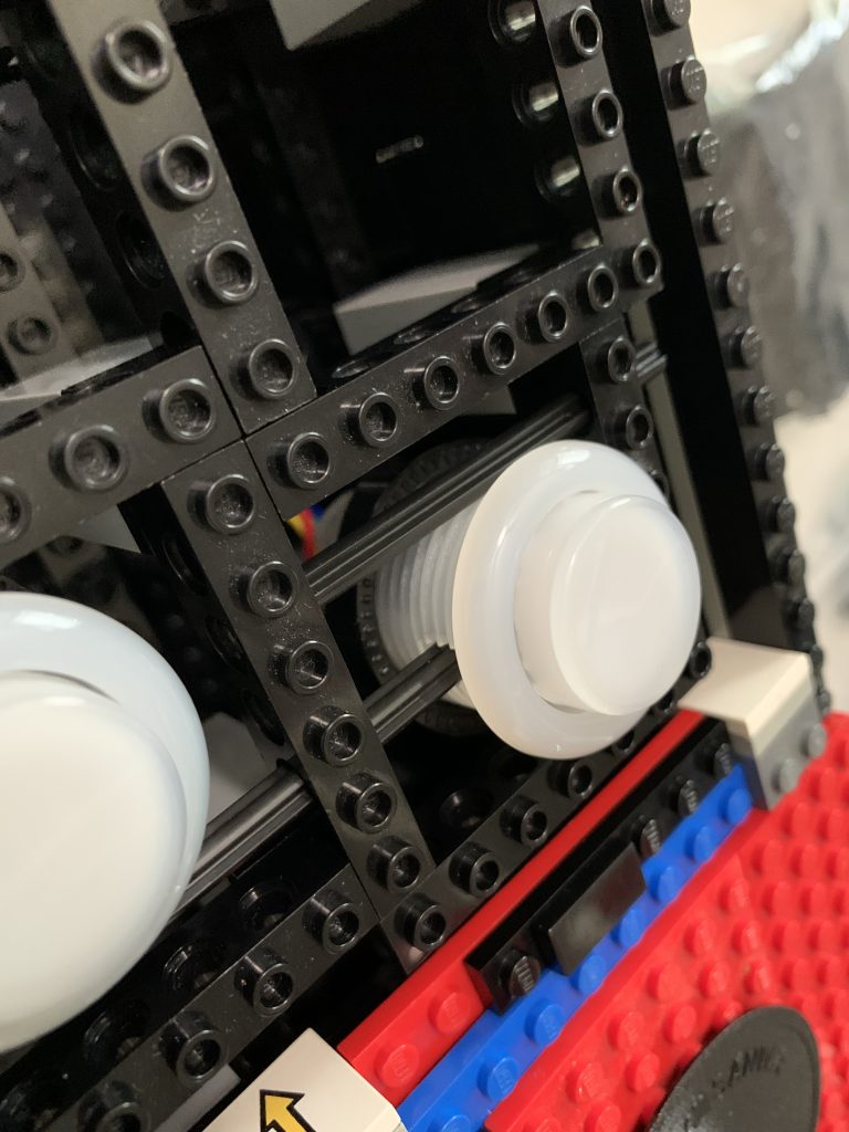 Photo showing a button being held in place by technic beams.