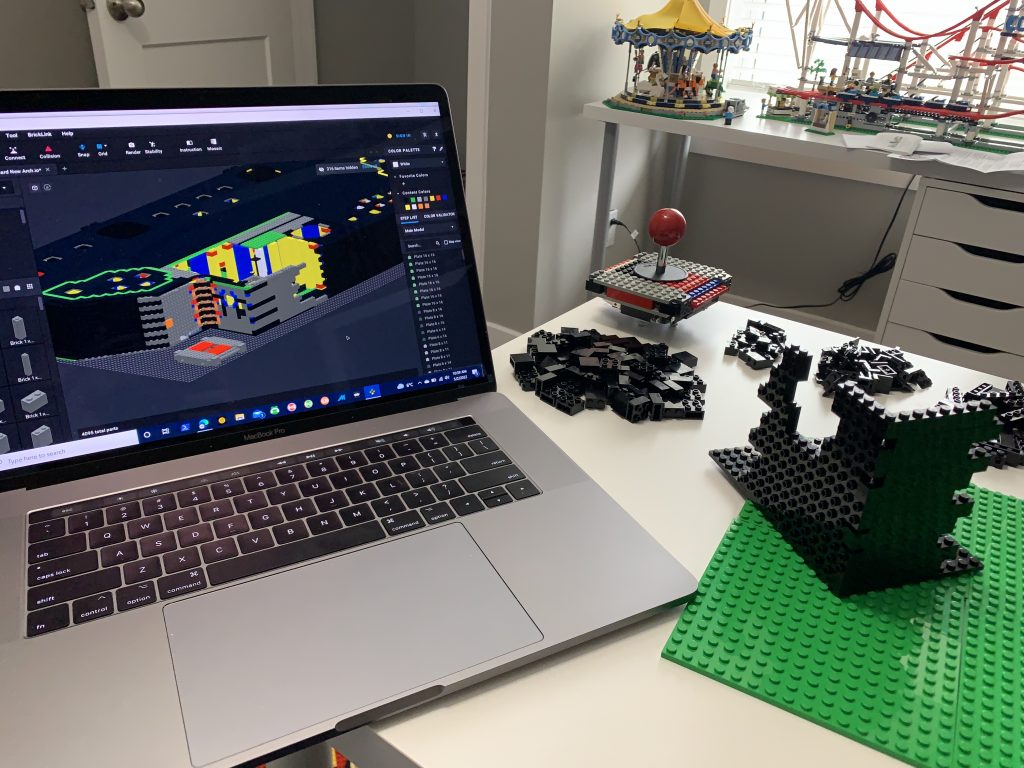 Photo showing beginning of control panel build sitting on table next to computer displaying the full design.