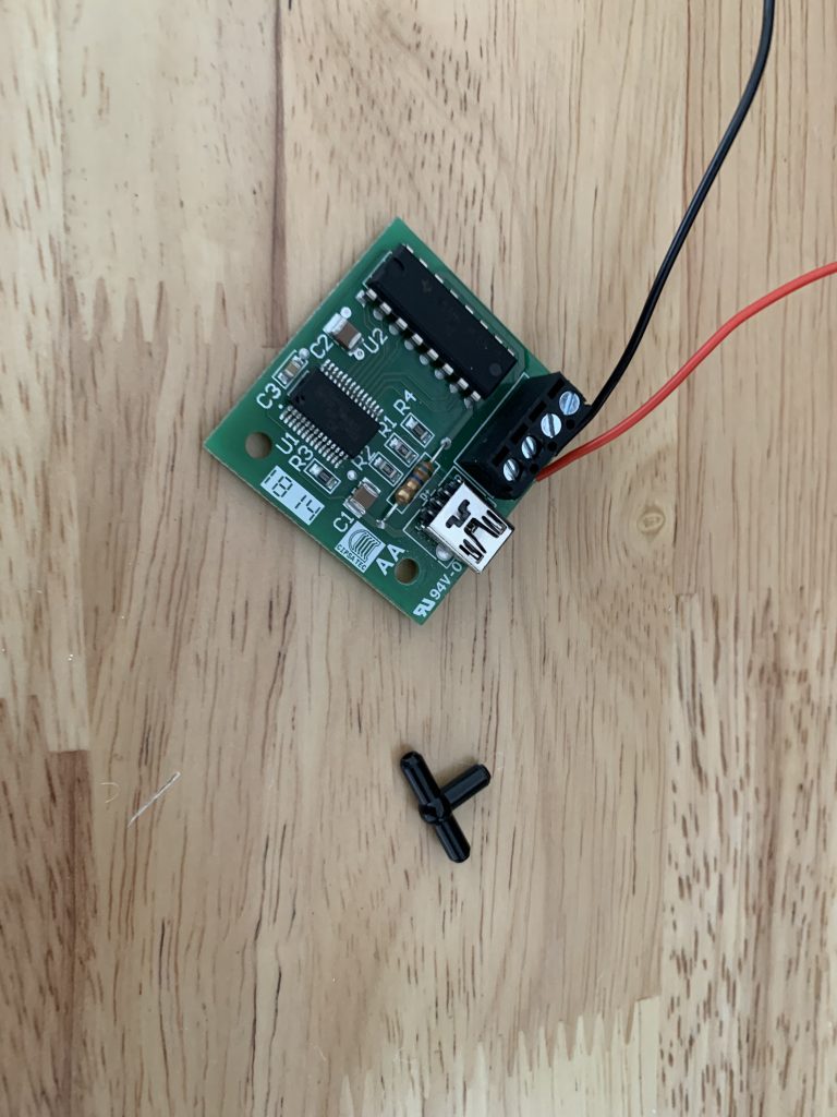 Photo showing the Ultimarc ServoStick Control Board alongside a LEGO pneumatic T piece