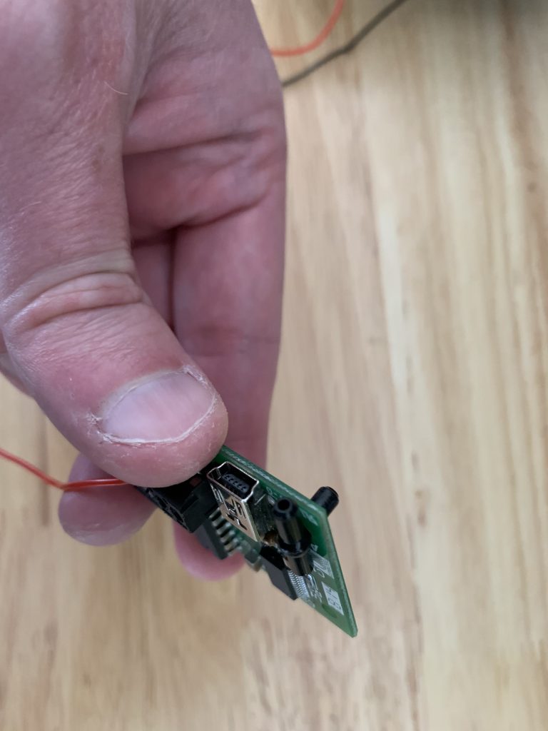 Photo showing the pneumatic T piece fitting nicely into one of the mounting holes of the Ultimarc ServoStik Control Board