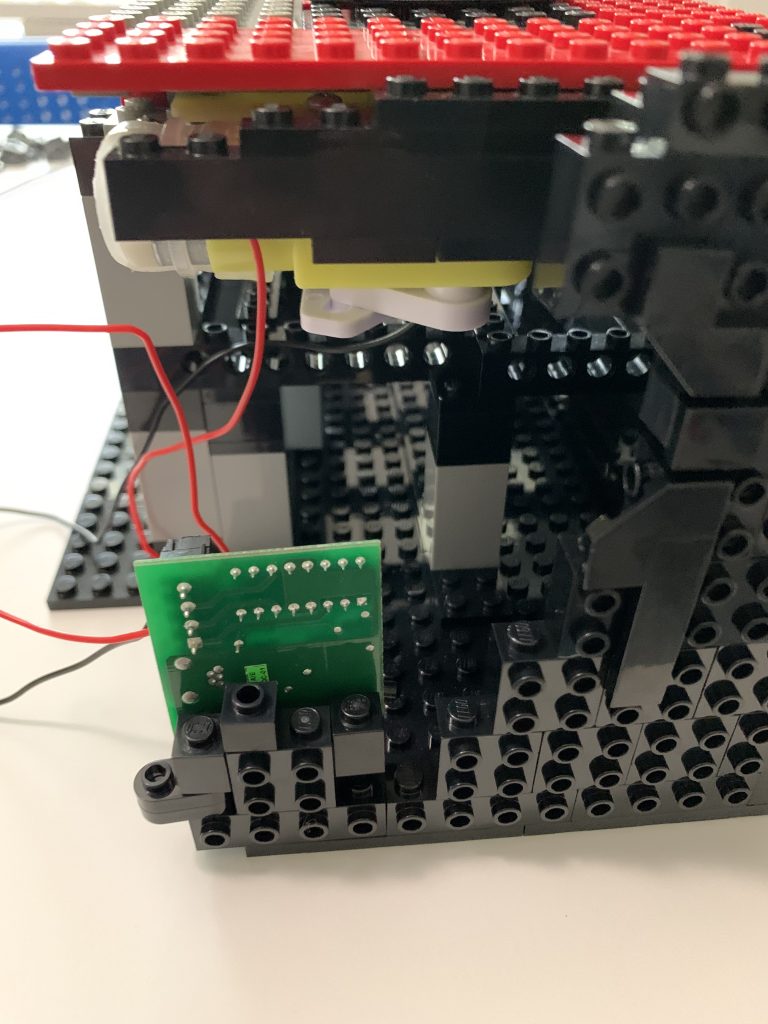 Photo showing the Ultimarc ServoStik Control Board mounted to the side of the control panel using only LEGO.