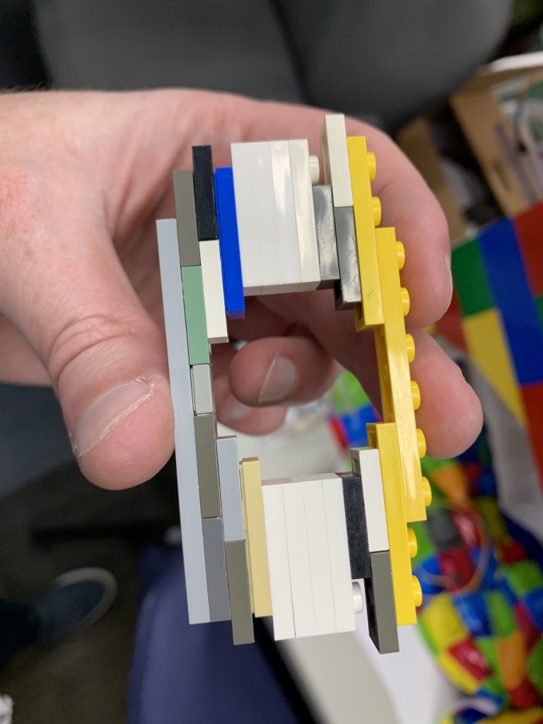 Photo showing a bunch of multi-colored plates stuck together to form a more exactly-sized hole for the button to attach to.