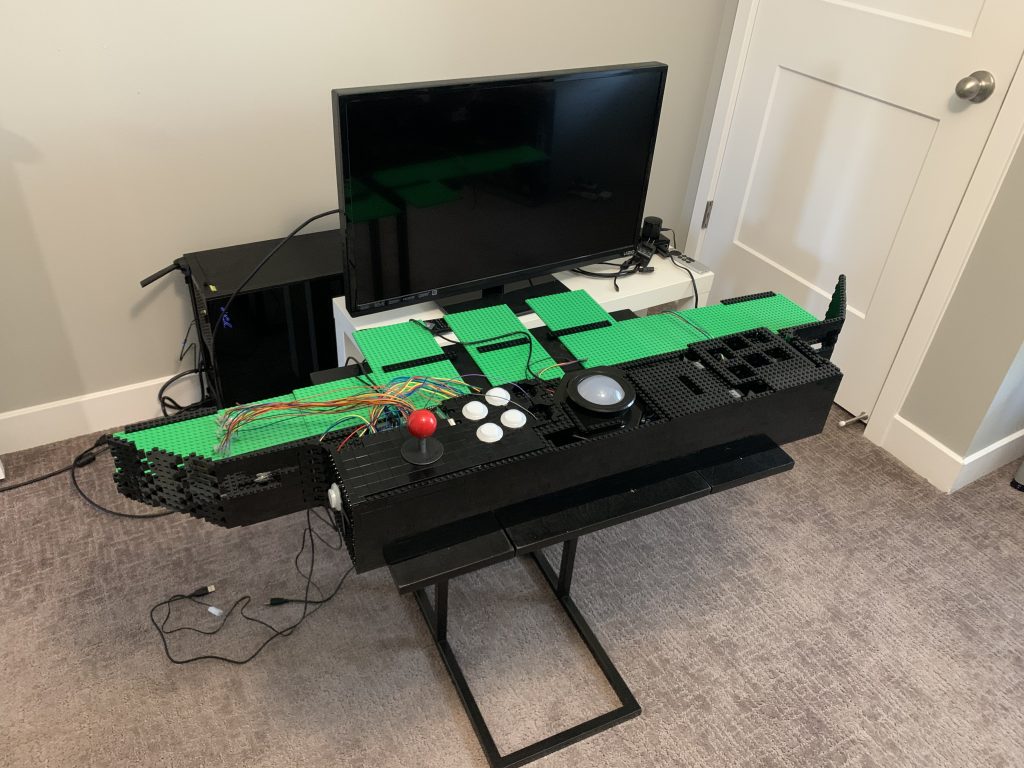 Photo showing control panel sitting on small coffee table with the ends of the control panel dangling off the sides.