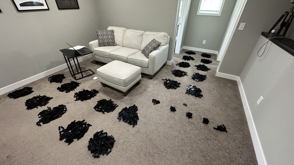 Photo showing the 2x8 brick sorted into twenty piles of 100 and then five piles of 10 and one pile of two. 2,052 brick!