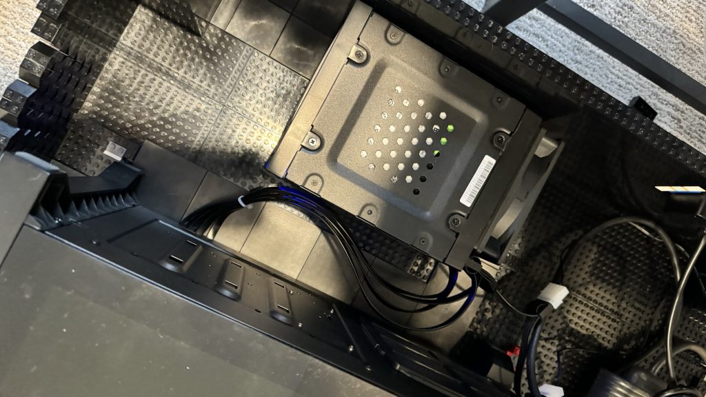 Photo of hot swap container holding four 18 TB hard drives, sitting inside the arcade base