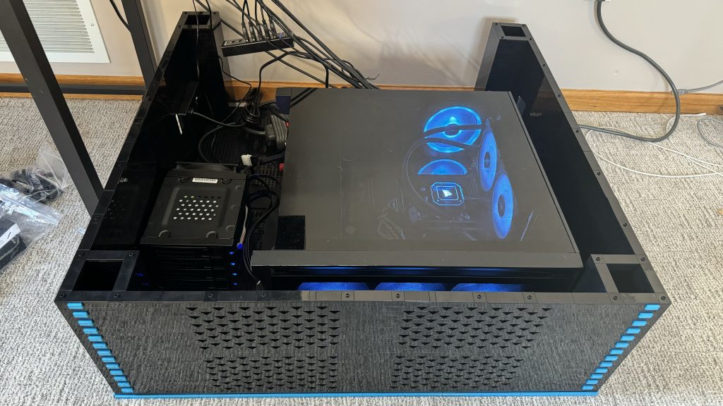 Photo showing the computer resting inside the cabinet base, with the fans and the CPU inside the case shimmering a nice blue color.