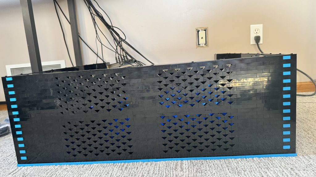 Photo of the completed base. The way the ventilation was put together with brick created an arrow pattern along the front of the cabinet. Dark azure tiles are stacked up on both sides. Looks like more than just a box.