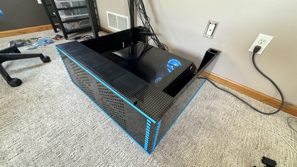 Photo of arcade base, with a new layer of 16x16 Technic brick resting on top and a horizonal line of dark azure 1x8 tiles along the perimeter.