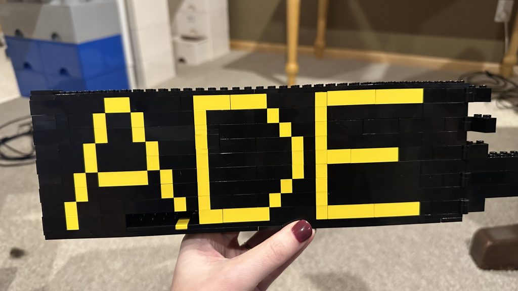 Photo showing the right half of the new door, now instead of Technic, yellow brick is used to form the letters A, D, and E