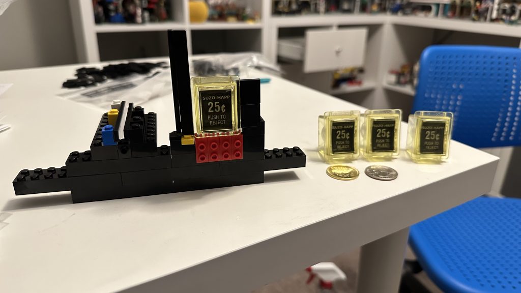 Photo taken of the early prototype holding one of the coin reject buttons - with three more sitting on a table next to it