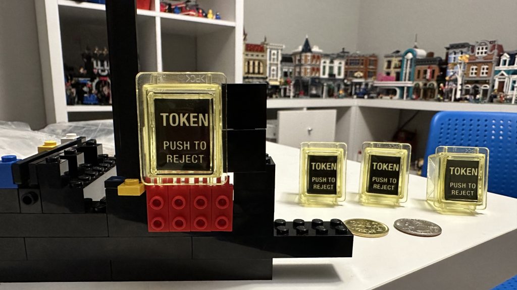 Close up photo of coin reject buttons sitting - three on table, one sitting in brick
