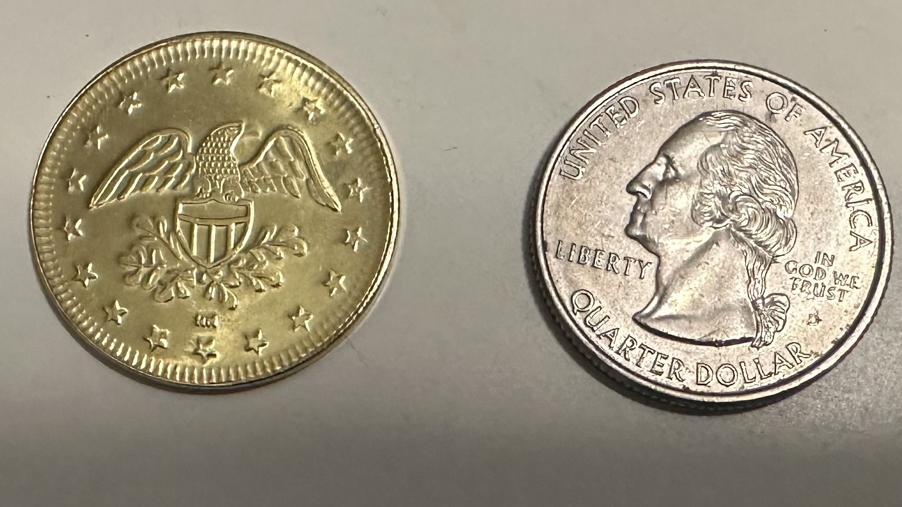 Picture showing the heads side of the token compared to the heads side of a US quarter