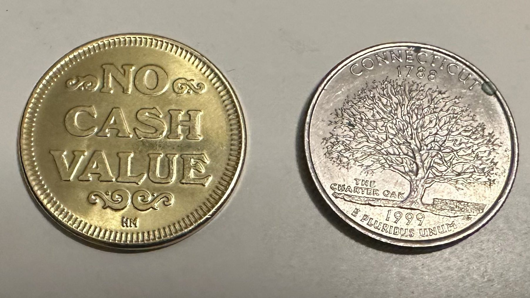 Picture showing the tails side of the token compared to the tails side of a US quarter