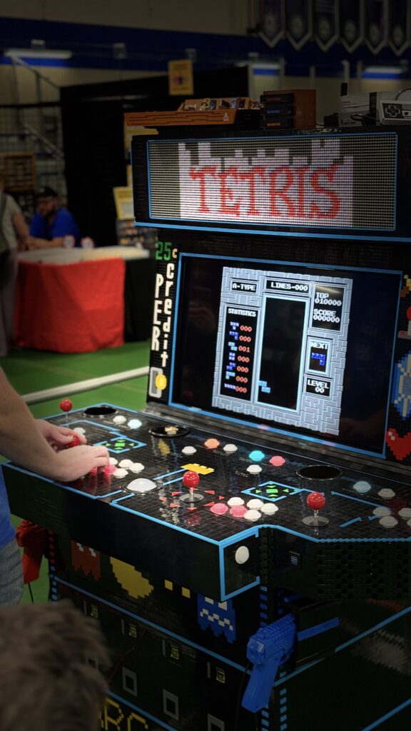 Photo of the arcade at the show with someone playing Tetris.
